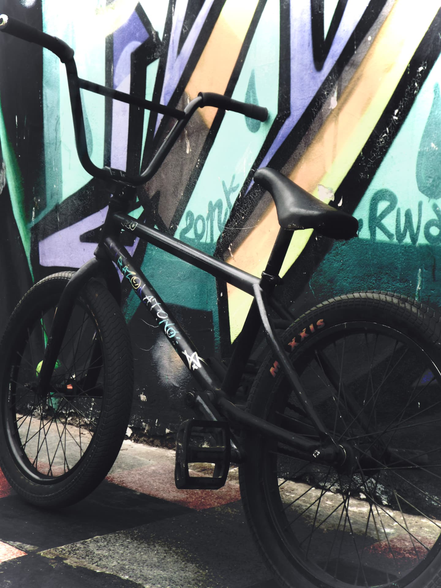 BMX frente a un mural de graffiti